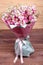 Bouquet of flowers with roses and Mattioli in pink package on wooden background. high quality
