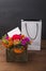 Bouquet of flowers with white card for congratulations. Gift bag.