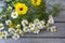 Bouquet of flowers on a wooden background. Wildflowers top view. Chamomile and daisies