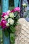 Bouquet of fragrant English pink and white roses in a bag of raffia hanging on the fence