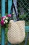 Bouquet of fragrant English pink and white roses in a bag of raffia hanging on the fence