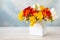 Bouquet of fresh multicolored freesias in a white vase