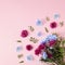 Bouquet of fresh Spring colorful flowers and leaves with copy space. Creative plant, floral concept on pastel pink background