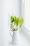 Bouquet of fresh spring lilies of the valley in a white jug on t