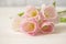 Bouquet of gently pink tulips on white wooden table. Thin petals of tulip flowers with stamens and peaches, group of pink flowers