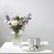 Bouquet of hackelia velutina, purple and white roses, small tea roses, matthiola incana and blue iris in glass vase is on the
