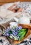 Bouquet hyacinth flowers and teapot with fresh tea are on bed for sleeping person