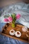 A bouquet of hyacinths, two cups of cappuccino stand on an old wooden tray