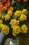 Bouquet with large yellow roses in a white flowerpot by the window in the city shop