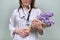 Bouquet of lilac flowers in the hands of female doctor with stethoscope