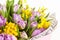 Bouquet of lilac tulips and yellow mimosas in pink box on white background, closeup, side view. March 8, February 14, birthday,