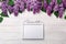 A bouquet of lilacs with a white frame for inscription on white boards