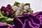 Bouquet of lillac flowers and purple drapery on white background