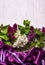 Bouquet of lillac flowers and purple drapery on white background