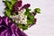 Bouquet of lillac flowers and purple drapery on white background