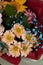 A bouquet of many different varieties of flowers close up in red and light gray packaging