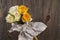 Bouquet of multicolor roses in watering can over wooden background.