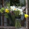 Bouquet of narcissus, carnations, eucalyptus, fern and hydrangea in a glass jar