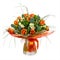 Bouquet of narcissus, tulips and other flowers in glass vase.