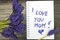 Bouquet and notepad with words `I love you mom`