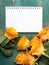 Bouquet of orange roses and blank notebook