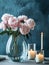 Bouquet of peonies in a glass vase and burning candles.