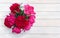 Bouquet of pink multicolored peonies on background of white painted wooden planks with space for text. Top view, flat lay.