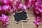 Bouquet of pink orchids and blank blackboard label on wooden background