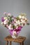 Bouquet of pink roses, alstroemeria flowers and orchids. Fresh summer flowers on gray background