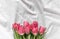 Bouquet of pink tulips on the bed. Top view, close up. Flat lay. Flowers for Valentines, Women’s day