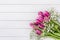 Bouquet of pink tulips and gipsophila flowers on white wooden background. Top view