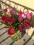 bouquet of pink tulips in vase on a balcony on a sunny spring day