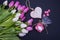 Bouquet of pink and white tulips on the left side, wooden heart and lollipops