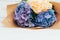 Bouquet of purple, blue and yellow hydrangeas on a white wooden table. Flowers background