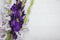 Bouquet of purple gladiola flowers laying down on a white wooden backdrop