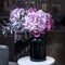 bouquet of purple hydrangeas and eucalyptus in brown glass vase