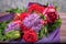 Bouquet with red flowers in purple packaging on wooden background. high quality