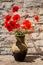 Bouquet of red poppies in clay jug on wooden table