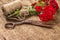 Bouquet of Red Roses, ball of Twine and Old Rusty Scissors on Wooden Table