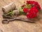 Bouquet of Red Roses, ball of Twine and Old Rusty Scissors on Wooden Table