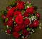 Bouquet of red roses, chrysanthemums and veiled flowers formed by florist