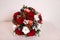 Bouquet with red roses, cotton balls, cones, spruce and other flowers. Circle flowers bunch and book on table, top view