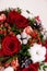 Bouquet with red roses, cotton balls, cones, spruce and other flowers. Circle flowers bunch. Close up