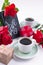 A bouquet of red roses and fresh aromatic tea for a romantic breakfast. Flowers and a letter as a gift. Valentine`s day and mothe