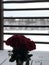 A bouquet of red roses in a vase on a snow-covered wooden brown balcony in a country house on the background of a winter forest