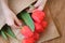 Bouquet of red tulips in child`s hands in a package of craft on