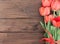 Bouquet of red tulips on wooden background with space for text