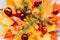 Bouquet of red and yellow dry autumn maple leaves stacked on top of each other, on top of them are chestnuts, maple seeds, and a s