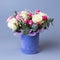 Bouquet of roses in a blue velor round gift box on a blue background.