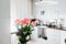 Bouquet of roses with card left on kitchen. Modern kitchen design. Interior of kitchen decorated with flowers